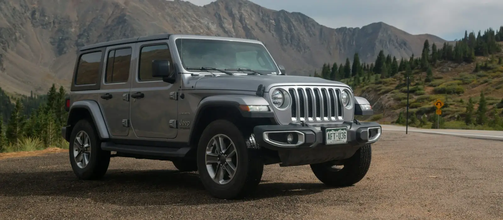 Silver Jeep Wrangler parked along mountain road. Southwest Muffler & Brake, Stafford and Houston.