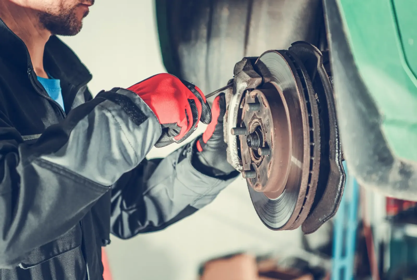 Mechanic working on car disc brake assembly. Southwest Muffler & Brake, Stafford and Houston.